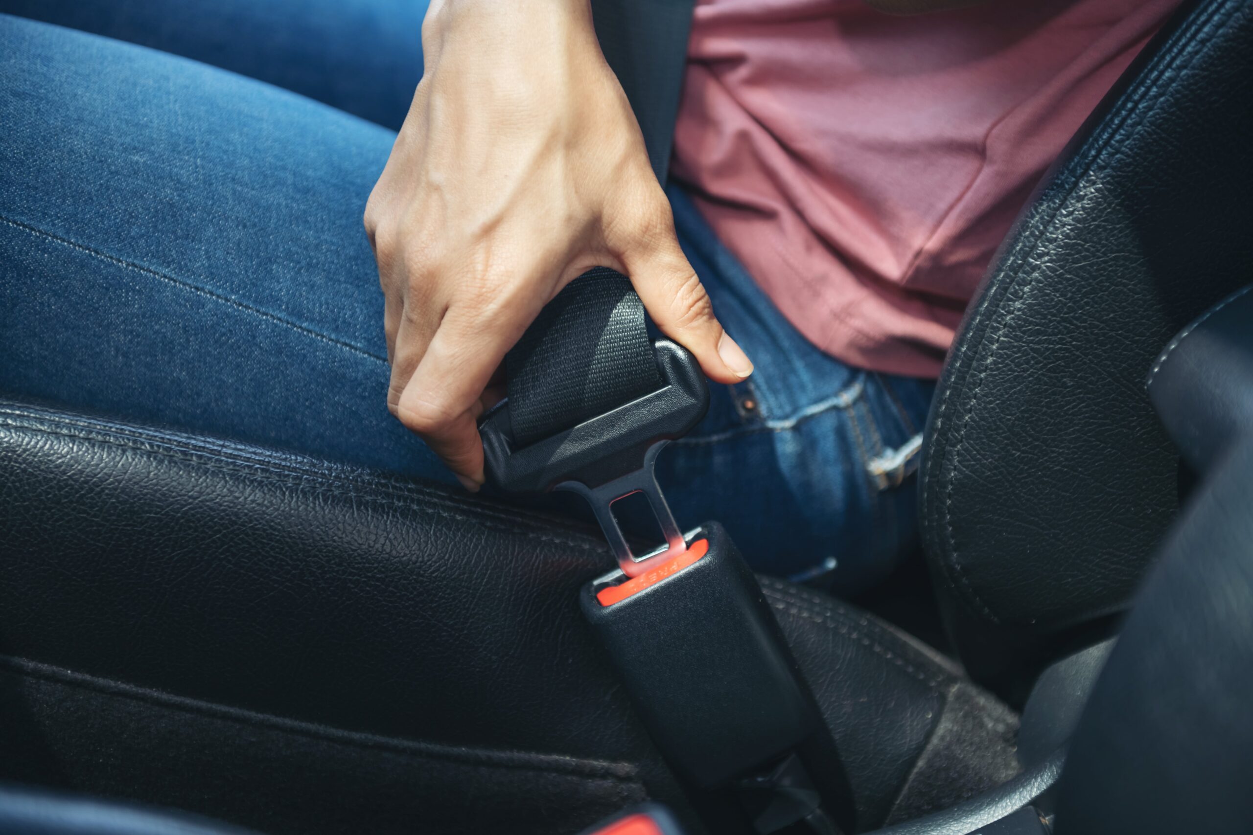 woman hand fastening seatbelt car safe driving